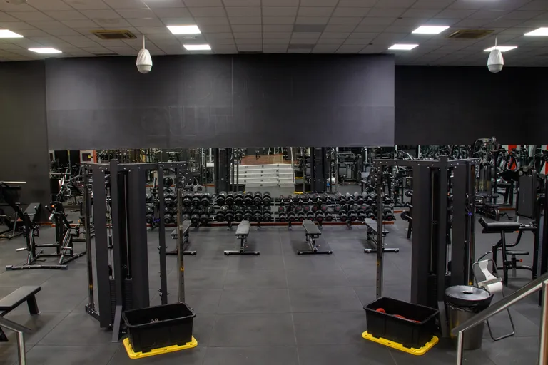 Squat racks y zona de peso libre en la sala de musculación de Palladium