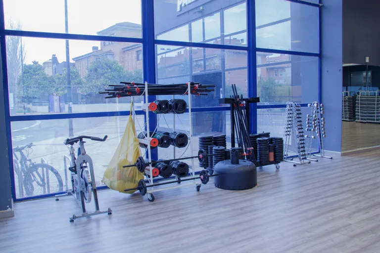 Material de BodyPump con barras y discos en la sala de actividades de Palladium